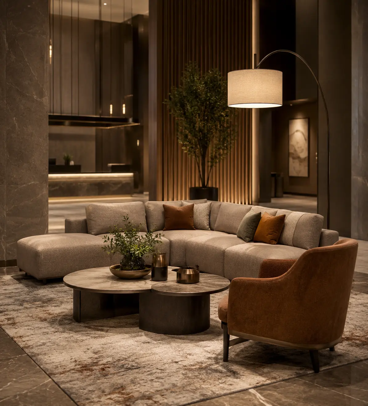 Hotel lobby seating arrangement with beige curved-back lounge chairs facing a beige loveseat sofa, round marble coffee table, ceramic table lamp on a wood side table and a large framed wall art in a warm wood-paneled hotel interior.